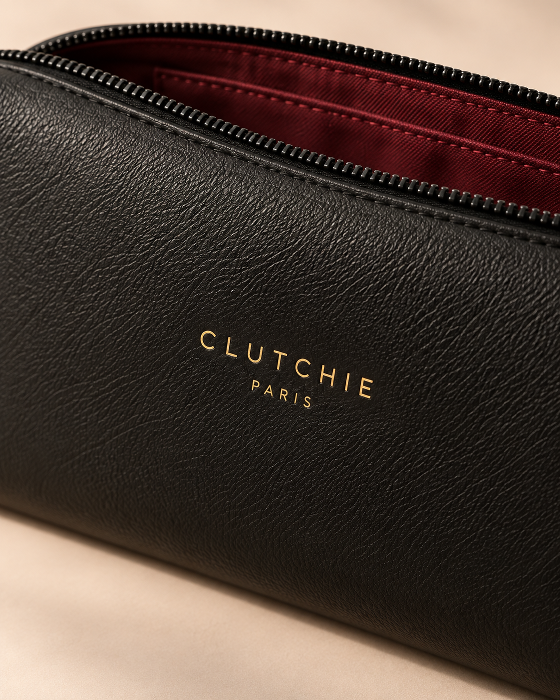 Détail de la matière noire grainée et du logo champagne CLUTCHIE PARIS